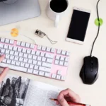 Multi-colored silicone adhesive cable management clips on a wooden desk.