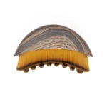 Crescent shaped ergonomic makeup brush for facial contouring and foundation.