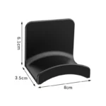 Black adhesive headphone hook holding over-ear headphones under desk