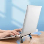 Invisible adhesive laptop stand elevating a silver laptop