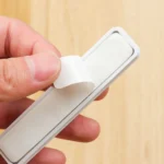 Magnetic cable organizer clips with adhesive base strip for desk.