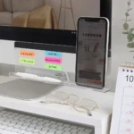 Clear acrylic monitor shelf with phone holder and desk organizer.