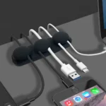 Adhesive silicone cable organizer for desk and wall management.