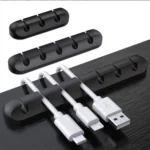 Black silicone cable organizer with adhesive backing holding multiple cords