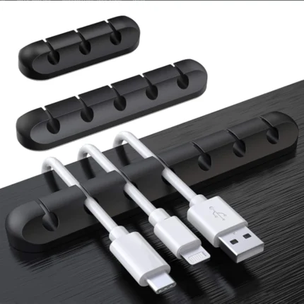 Black silicone cable organizer with adhesive backing holding multiple cords
