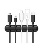 Black silicone cable organizer with adhesive backing holding multiple cords