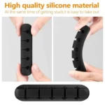Black silicone cable organizer with adhesive backing holding multiple cords