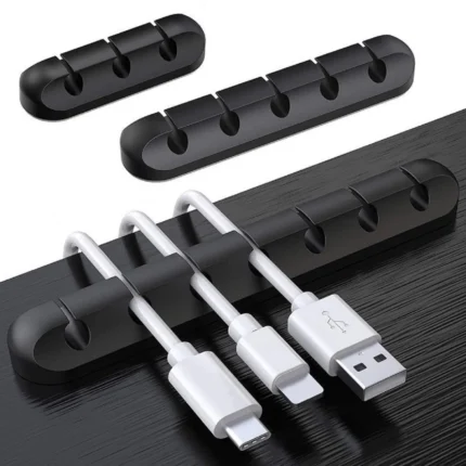 Adhesive desk cable organizer clips holding multiple data and charging cables