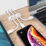 Adhesive desk cable organizer clips holding multiple data and charging cables
