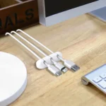 Adhesive desk cable organizer clips holding multiple data and charging cables