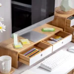 Bamboo monitor stand with white storage drawers and cable cutout