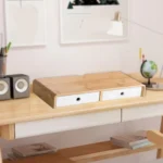Bamboo monitor stand with white storage drawers and cable cutout