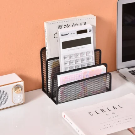 Black metal mesh desk organizer with three compartments holding office supplies.