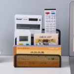 Black metal mesh desk organizer with three compartments holding office supplies.