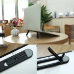 Slim adhesive foldable laptop stand elevating a black laptop.