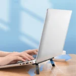 Slim adhesive foldable laptop stand elevating a black laptop.