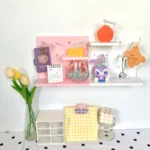 Pink pegboard wall organizer with shelves for cute collectibles.