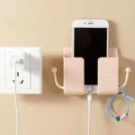 Self-adhesive wall phone holder with charging slot and side hooks